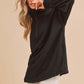 Stylish woman in a black exposed seam half zip drop shoulder sweatshirt, perfect for casual and trendy outfits.