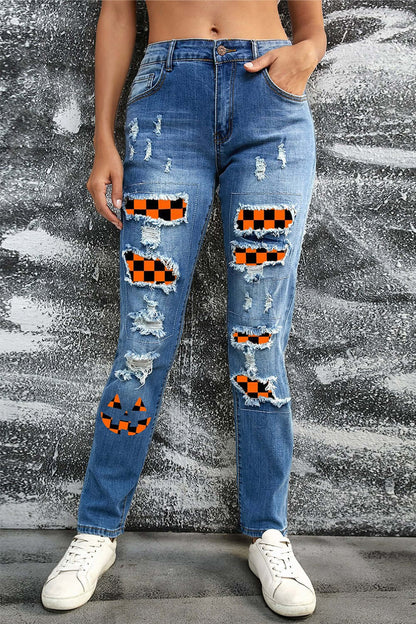 Woman wearing Bella Road distressed straight jeans with Halloween-themed patches and pockets in front of a textured background