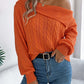 Woman wearing Bella Road Cable-Knit One Shoulder Long Sleeve Sweater in orange, paired with jeans, showcasing the trendy and cozy design