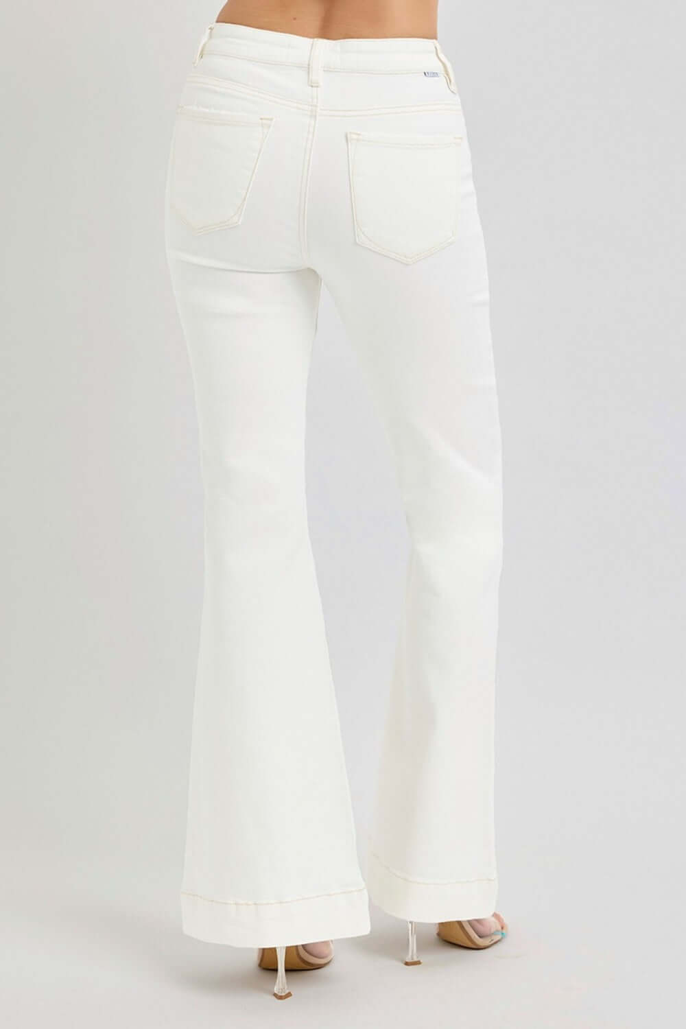 White high-rise flare jeans with patch pockets, shown from the back, highlighting stylish design and comfortable denim fabric.