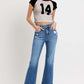 Model wearing RISEN Full Size Tummy Control High Rise Crop Bootcut Jeans with a black and white number 14 crop top