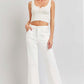 White high-rise ankle flare jeans with patch pockets, styled with a crochet crop top, showcasing a chic and casual look.