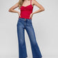 Woman in crop jeans and red top, showcasing flattering fit and stylish design for everyday wear.