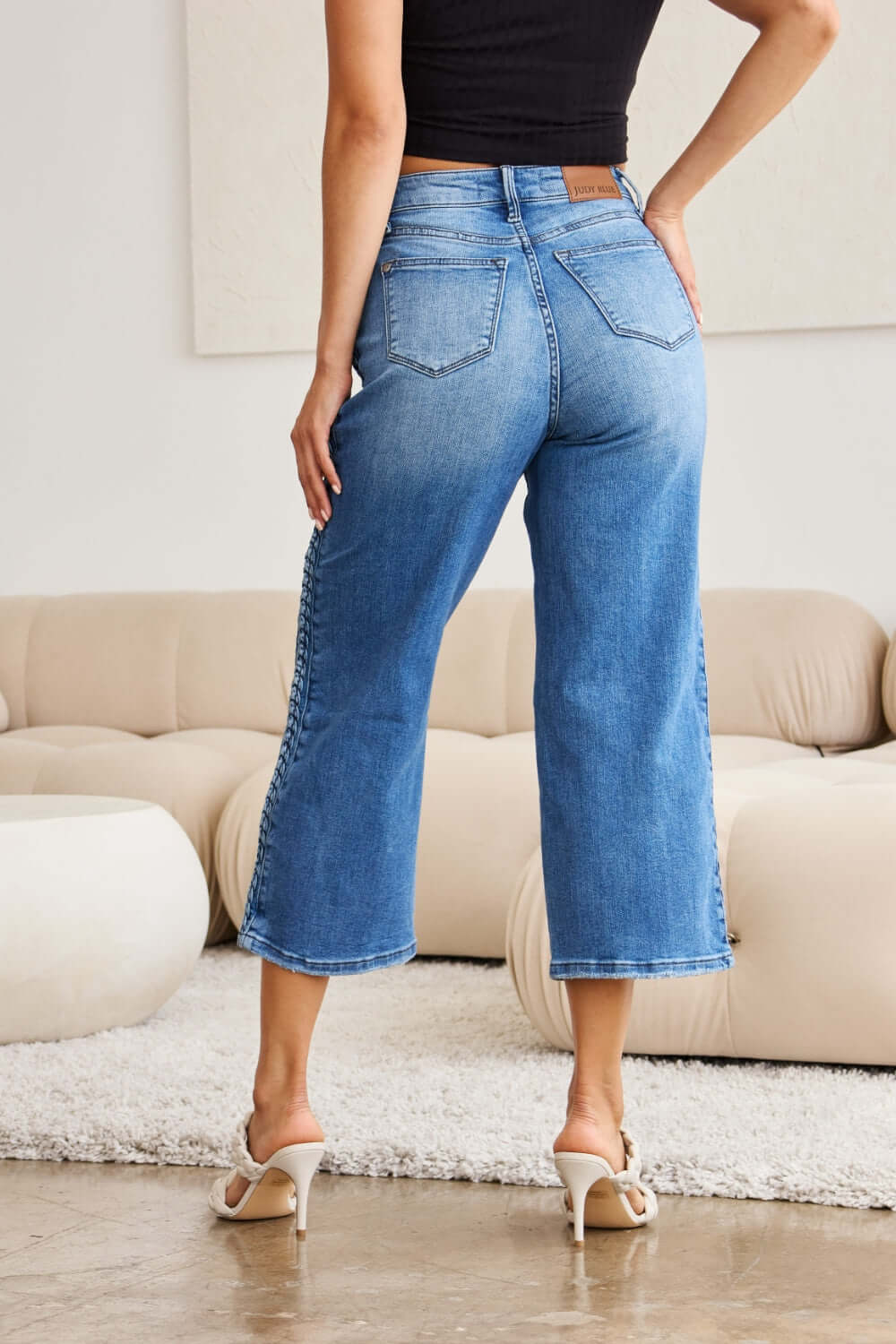 Woman wearing Judy Blue braid side detail wide leg jeans, back view showing unique braid detailing and fashionable design.