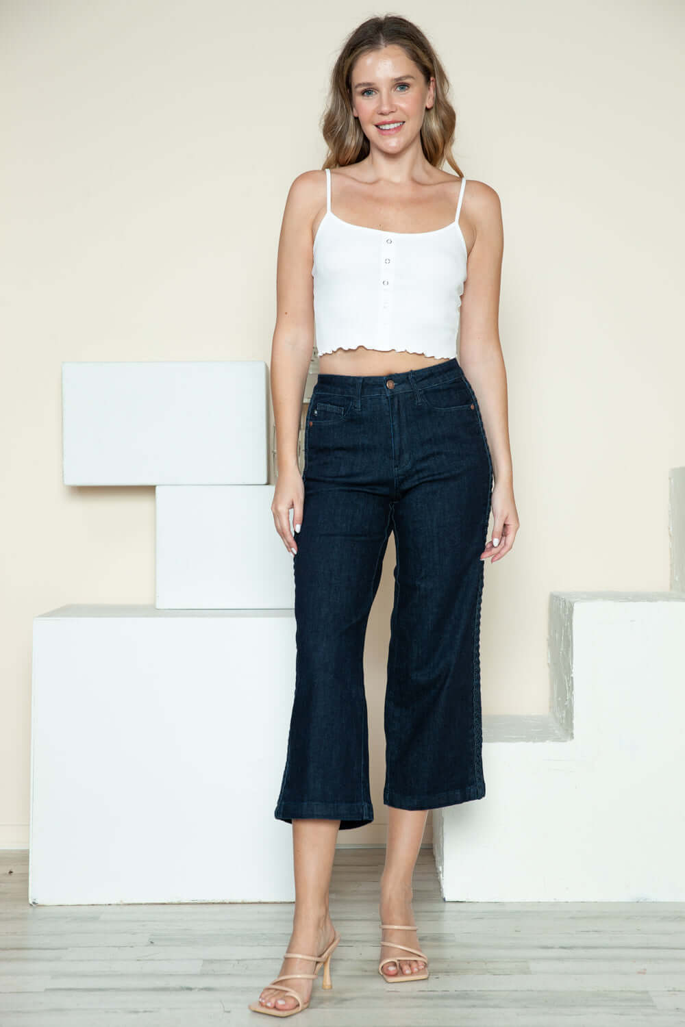 Woman wearing Judy Blue crop wide leg jeans with side seam braid detail and white top.