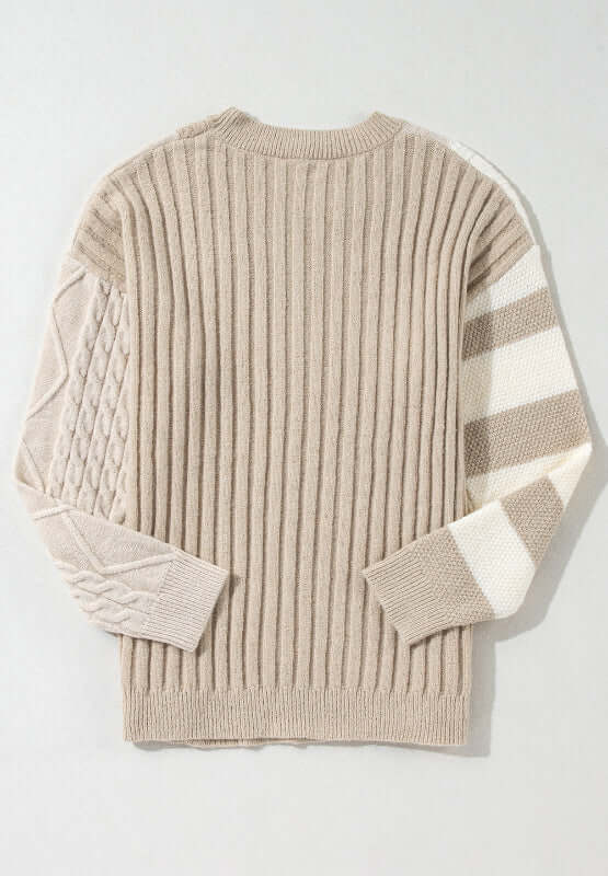 Bella Road cable-knit color block round neck sweater in tan, featuring unique knit patterns on sleeves, perfect for a cozy, stylish look.