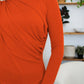 Woman wearing FAM-FAM Ruched Mock Neck Long Sleeve T-Shirt in vibrant orange, showcasing unique style ideal for fall fashion.