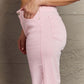 Woman modeling Raelene High Waist Wide Leg Jeans in Light Pink by Risen Jeans for a chic and comfortable look.