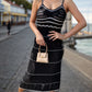 Stylish model wearing a black Bella Road Swim Openwork Spaghetti Strap Cover-Up by the beach, showcasing openwork details.