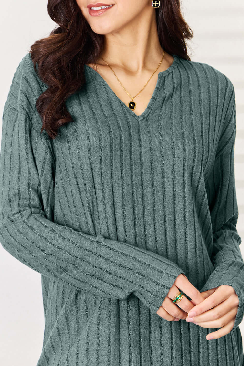 Woman wearing a ribbed notched long sleeve top from a two-piece set, in a basic style.