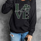 Woman wearing Bella Road LOVE Rhinestone Clover sweatshirt, showcasing chic style and sparkling details. Perfect for casual looks!