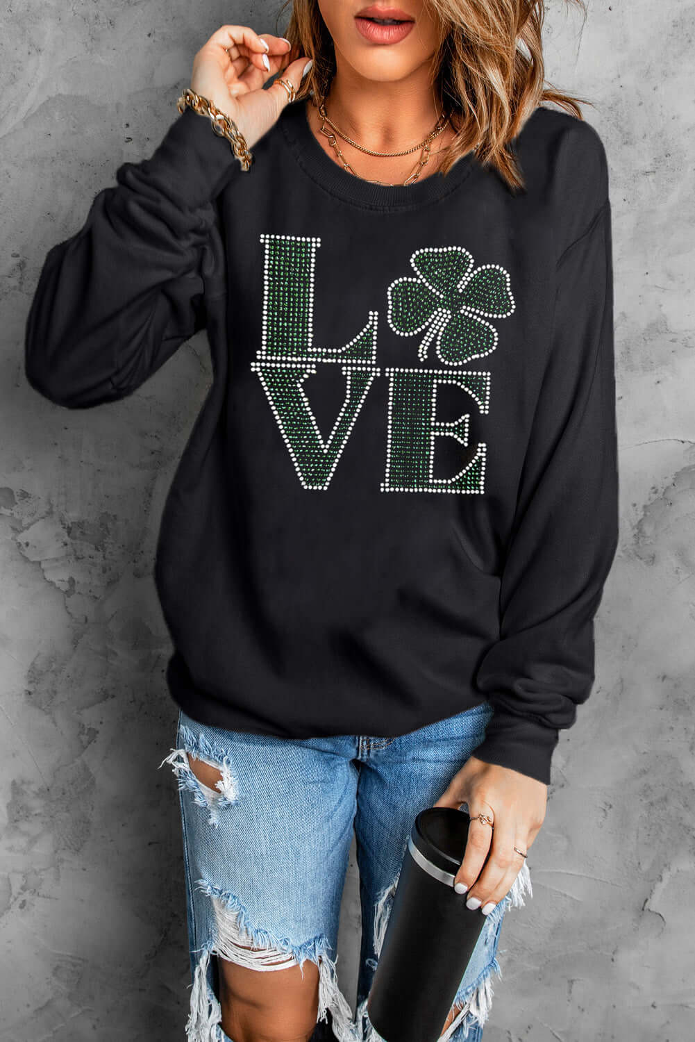 Woman wearing Bella Road LOVE Rhinestone Clover sweatshirt, showcasing chic style and sparkling details. Perfect for casual looks!