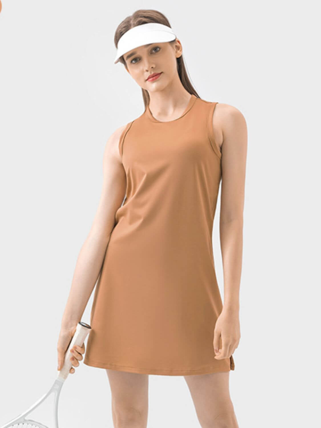 Millennia Round Neck Sleeveless Active Dress in caramel, perfect for workouts and sports, with stylish visor and tennis racket.