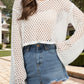 Sheer cream openwork long sleeve cover up paired with denim shorts, perfect for a stylish beach look.