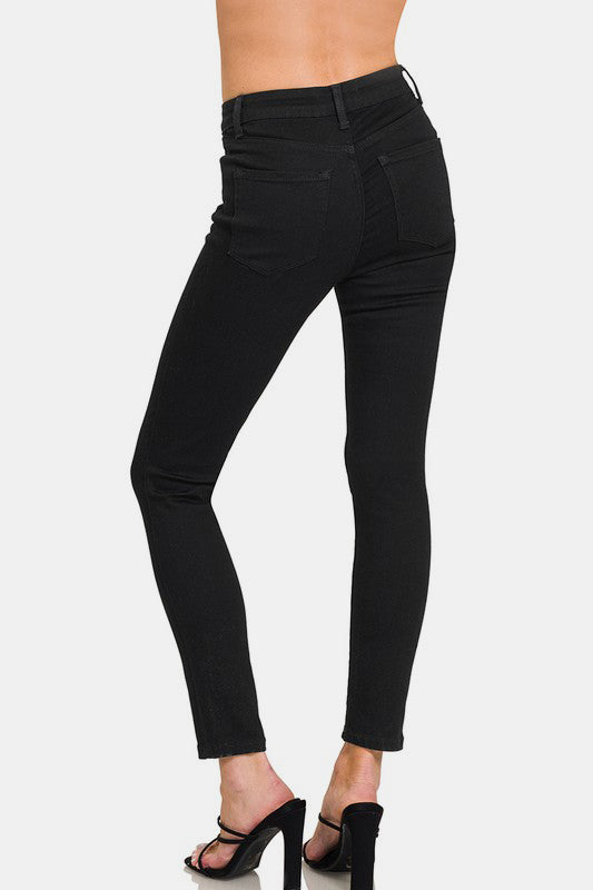 Model showcasing black high rise skinny jeans with pockets and a sleek, slim-fit design from the back.