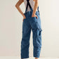 Woman wearing Bella Road Pocketed Wide Strap Denim Overalls in medium blue, showcasing back pockets and casual style.