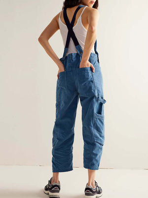 Woman wearing Bella Road Pocketed Wide Strap Denim Overalls in medium blue, showcasing back pockets and casual style.