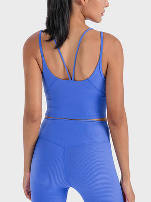 Back view of a woman in a blue Millennia Double Strap Ribbed Sports Cami, showcasing style and sporty support.