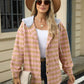 Woman wearing Bella Road Drawstring Plaid Long Sleeve Hooded Jacket in pink with a hat and sunglasses.