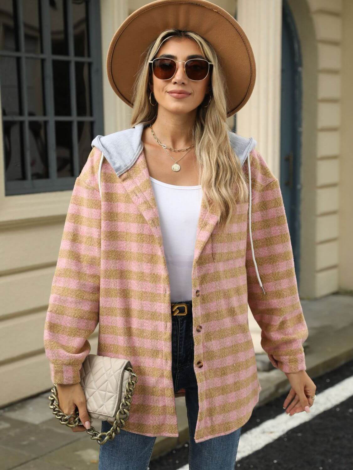 Woman wearing Bella Road Drawstring Plaid Long Sleeve Hooded Jacket in pink with a hat and sunglasses.