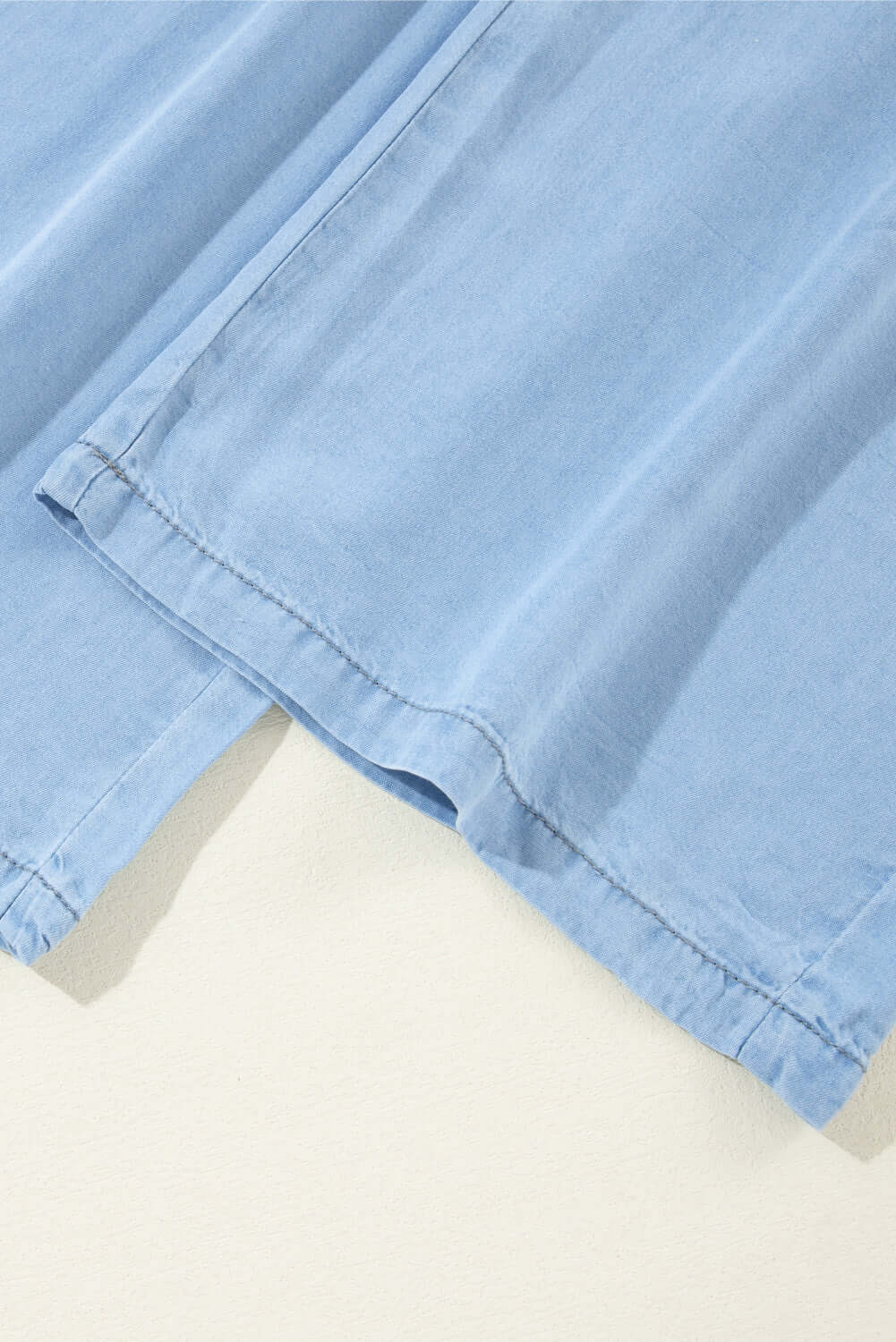 Close-up of the soft fabric and hem of Bella Road Drawstring Wide Leg Jeans in medium blue, showcasing comfort and style.