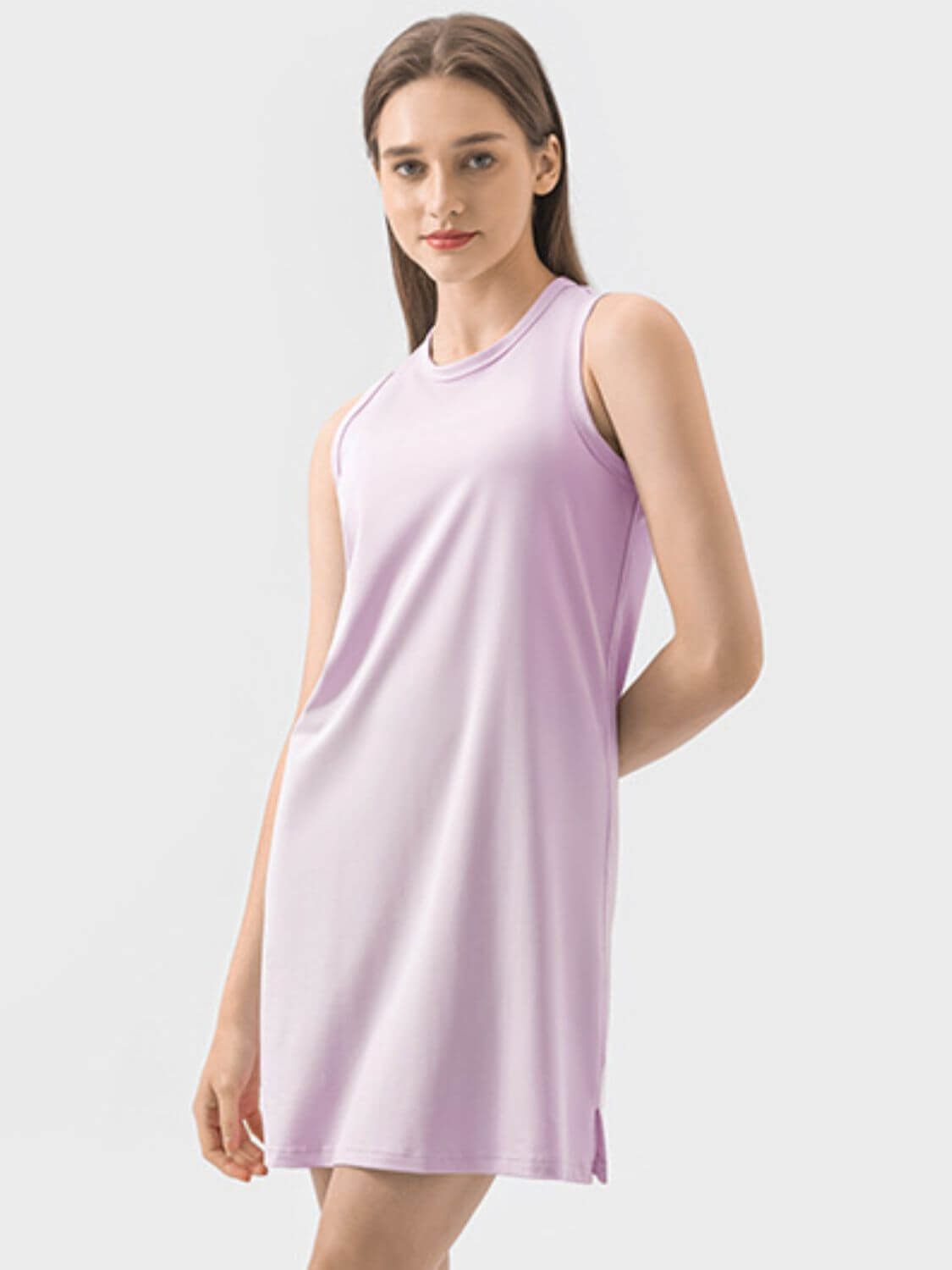 Model wearing a sleeveless purple Millennia active dress, showcasing its comfortable and stylish design for workouts.