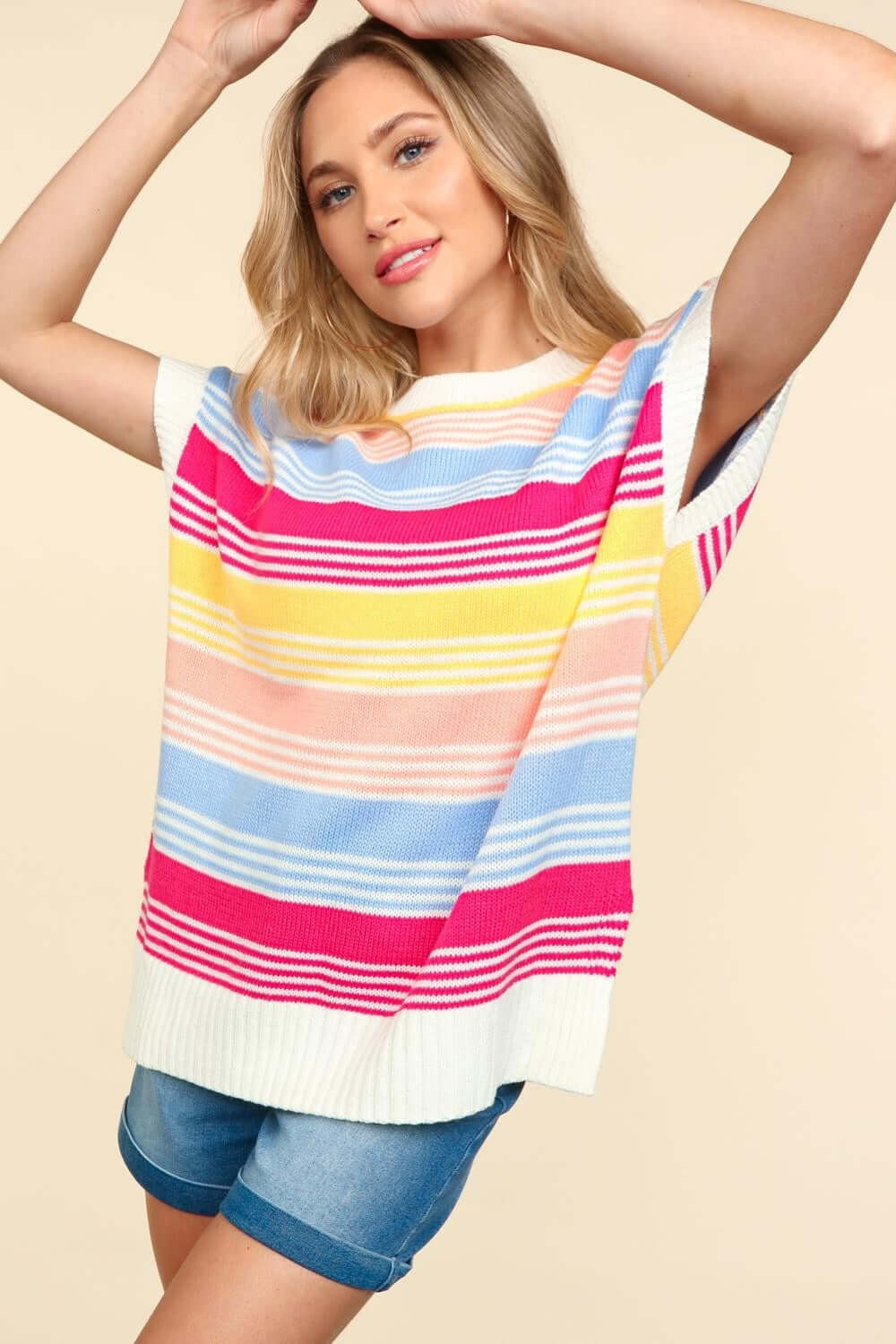 Woman wearing a Striped Side Slit Short Sleeve Knit Top in vibrant colors paired with denim shorts.