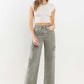 Woman wearing '90s Super High Rise Cargo Jeans with a white crop top and heels, showcasing vintage loose fit and cargo pockets.