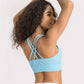 Woman showing the stylish crisscross back of a light blue active tank, perfect for workouts and comfort.