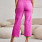 Woman wearing RFM Jeans Crop Chloe Full Size Tummy Control High Waist Raw Hem Jeans in vibrant pink, back view.