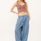 Woman wearing elastic back pleated baggy jeans with comfortable waistband and pockets, showcasing relaxed denim style.