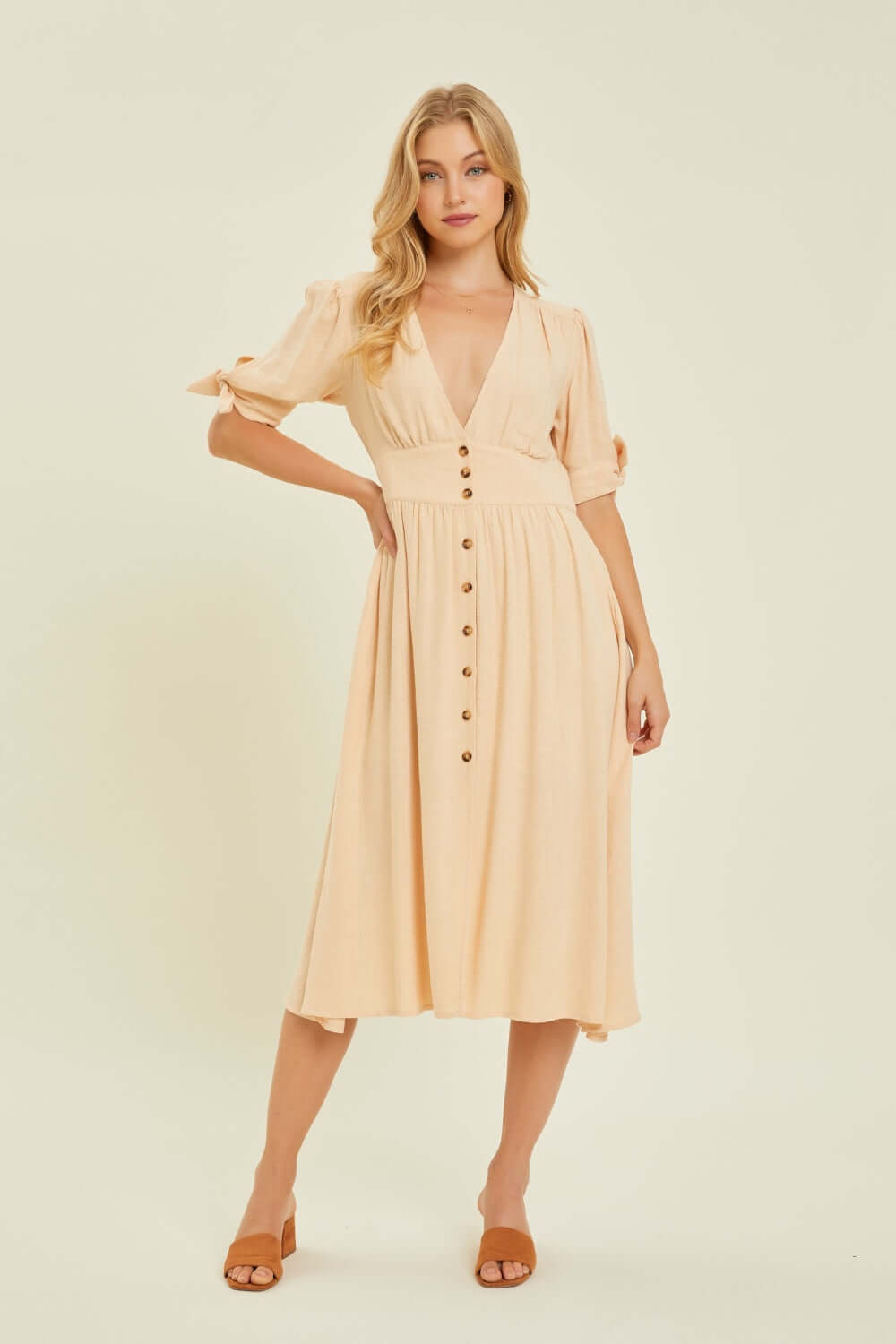 Stylish linen V-neck button-down midi dress in beige, perfect for warm weather occasions with an elegant and timeless design.