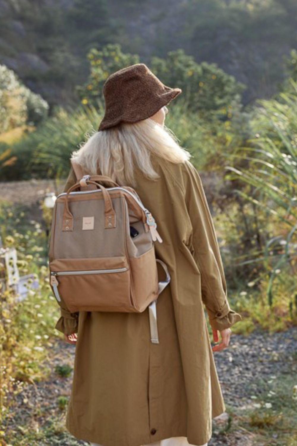 Woman wearing Himawari water-resistant canvas backpack with side pockets on a nature trail.