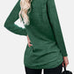 Woman wearing Bella Road green round neck long sleeve t-shirt with back pocket detail, paired with black pants, viewed from the back.