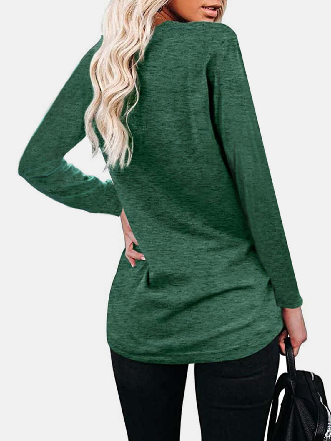 Woman wearing Bella Road green round neck long sleeve t-shirt with back pocket detail, paired with black pants, viewed from the back.