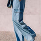 Stylish woman wearing light wash Bella Road Denim wide leg jeans with cargo pockets and a drawstring, paired with heels.