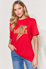 Woman wearing red MAMA round neck short sleeve T-shirt with lightning bolt graphic, paired with blue jeans.