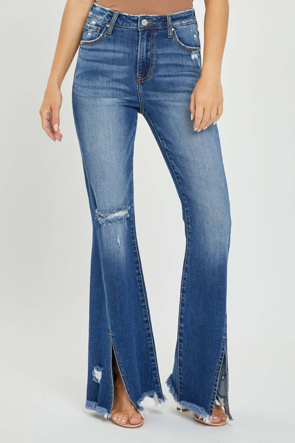 Trendy high-rise front slit frayed hem flare jeans by Risen Jeans flaunting a stylish retro look for casual outings.