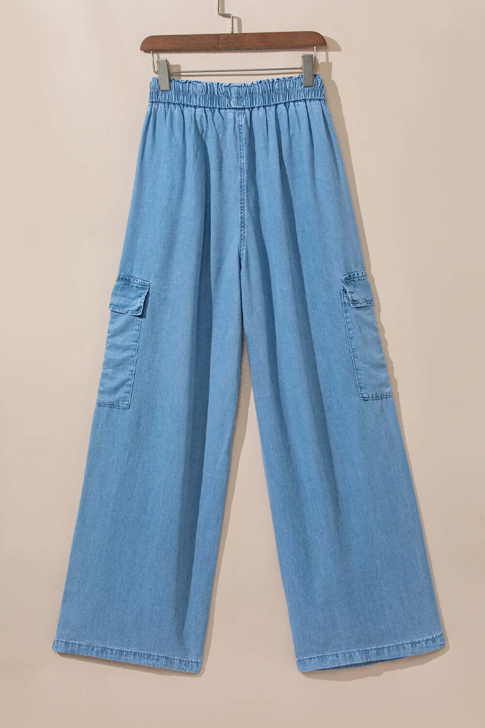 Light wash wide leg cargo jeans with drawstring waist and spacious pockets for a trendy, comfortable look.