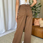 Woman wearing RFM Full Size High Rise Garment Dye Wide Leg Jeans in rich brown, showcasing the back view with a high-waist and relaxed fit.