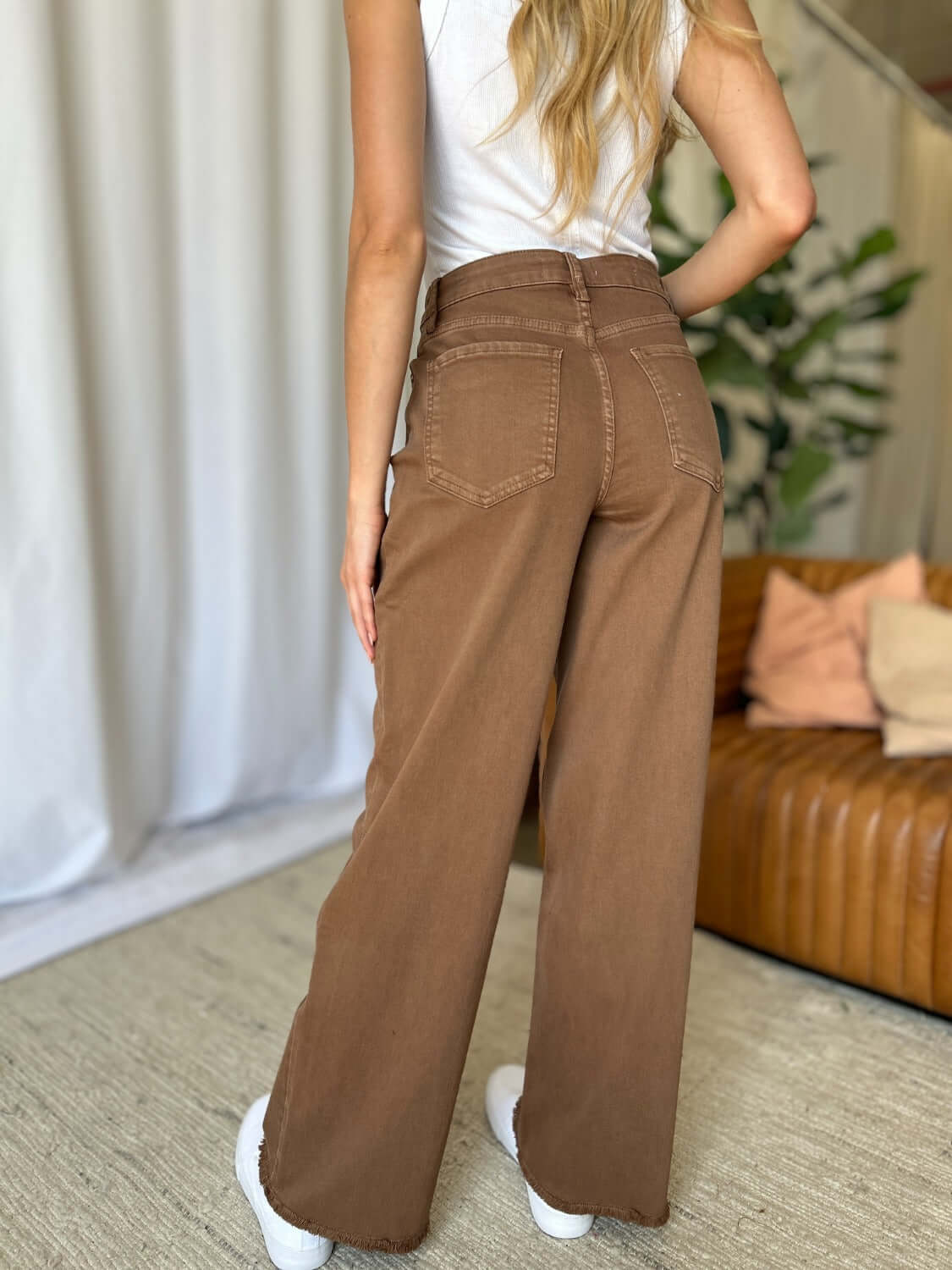 Woman wearing RFM Full Size High Rise Garment Dye Wide Leg Jeans in rich brown, showcasing the back view with a high-waist and relaxed fit.