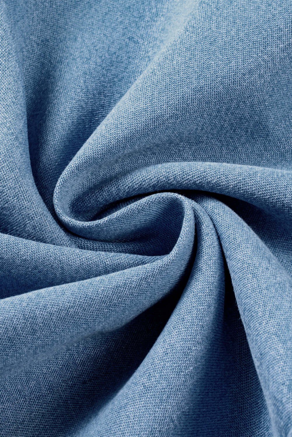 Close-up of soft light wash denim fabric in a swirling pattern, showcasing its texture and quality.