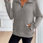 Woman wearing Ivy Lane Half Zip Raglan Sleeve Sweatshirt with pocket, shown in a room with light-colored walls.