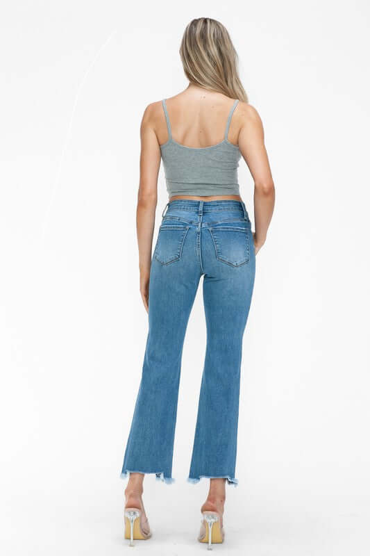 Back view of a model in bytos Raw Hem Distressed Mid Rise Crop Jeans, showcasing trendy cropped length and raw hem.