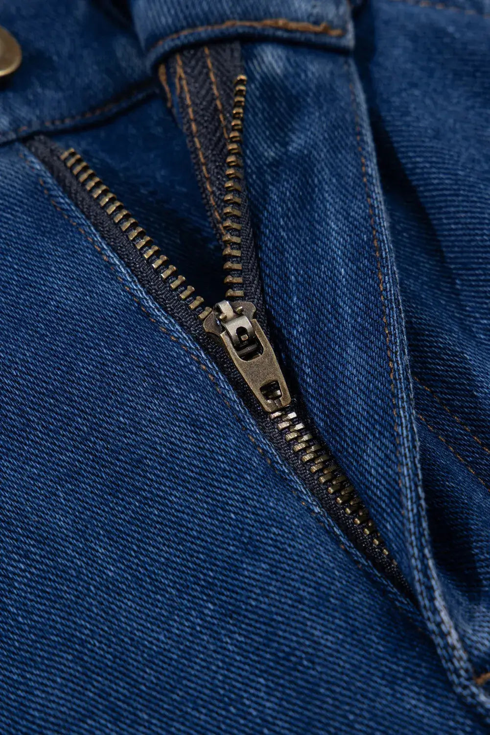 Close-up of zipper on straight jeans with pockets made from stretchy polyester, cotton, and elastane blend.