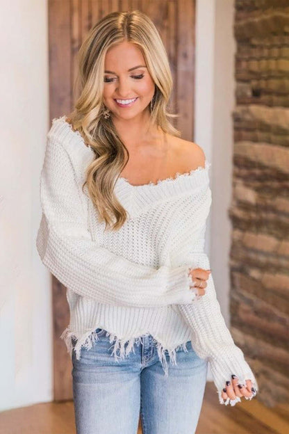 Woman wearing Bella Road frayed hem, dropped shoulder sweater in white, styled chic and cozy for casual fashion.