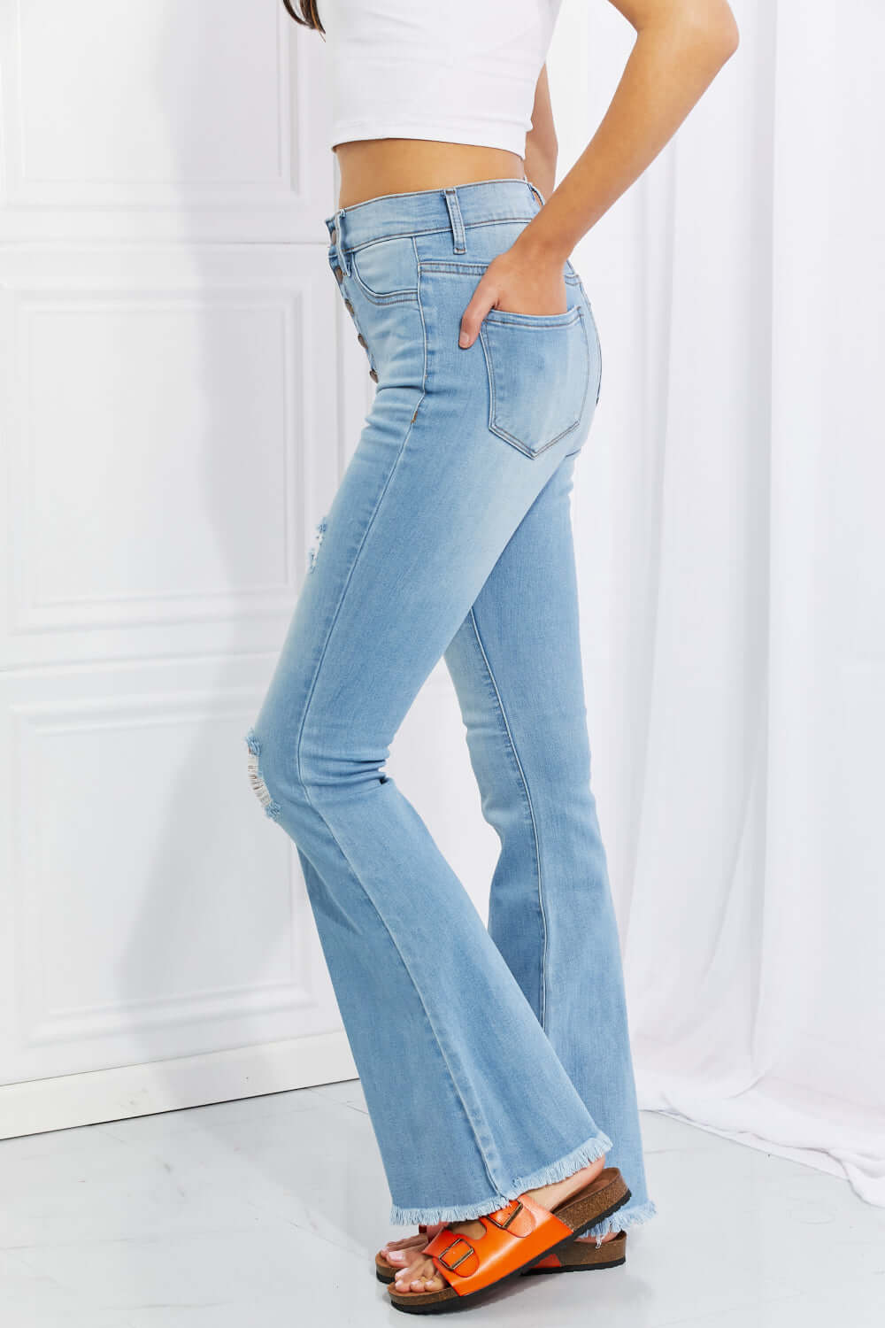 Woman wearing Vibrant MIU full size Jess button flare jeans with slight distressing and a frayed hem for a retro casual look.