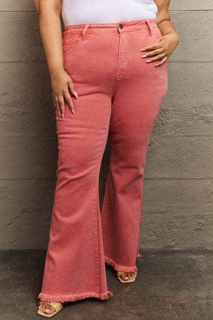 Woman wearing Bailey High Waist Side Slit Flare Jeans in coral with frayed hem, showcasing stylish Risen Jeans for a chic look