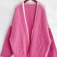 Pink open front contrast cardigan with dropped shoulders and white trim on a hanger, perfect for chic and relaxed style.