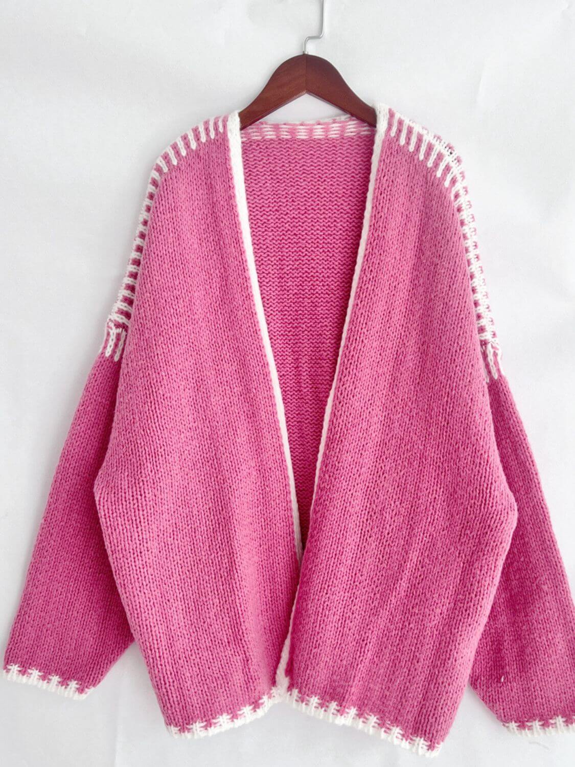 Pink open front contrast cardigan with dropped shoulders and white trim on a hanger, perfect for chic and relaxed style.